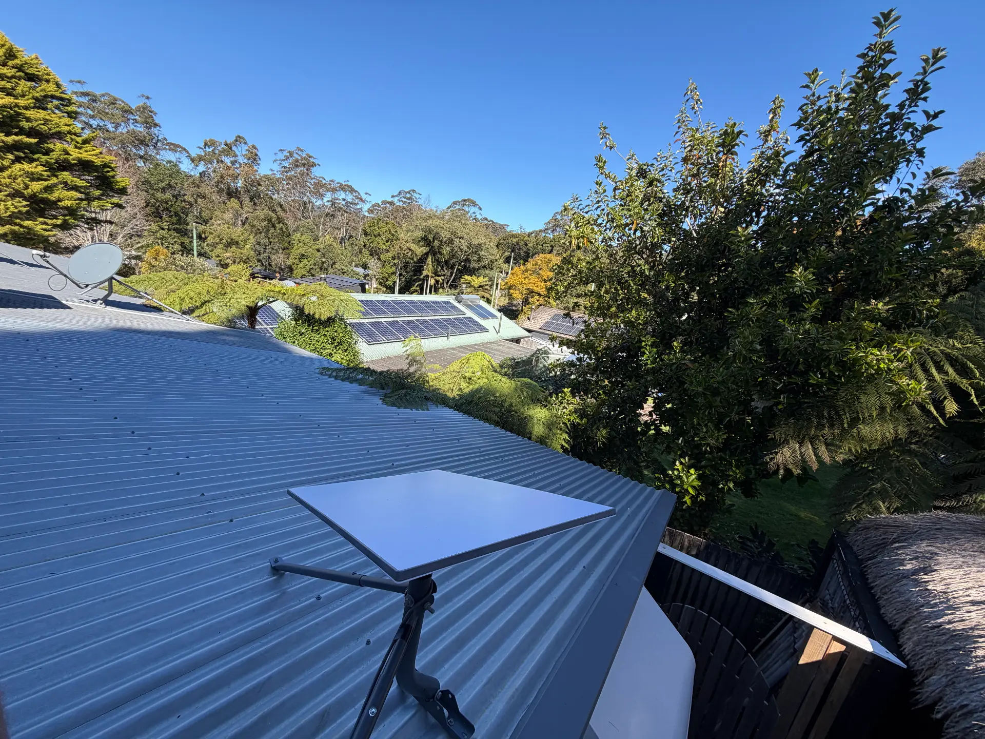 Starlink tripod installation on a hinterland roof surrounded by trees