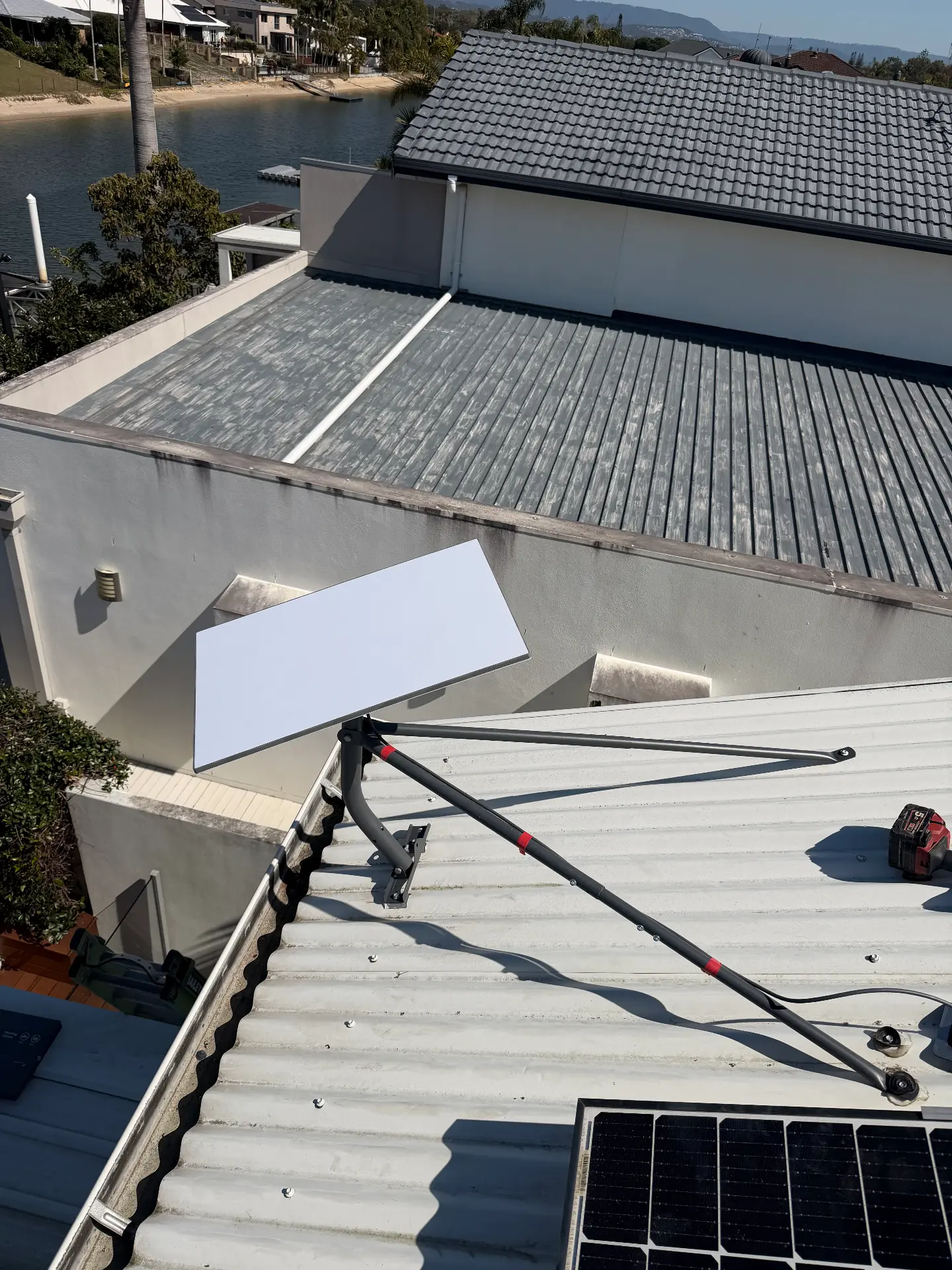 Starlink dish mounted high on a canal-front home