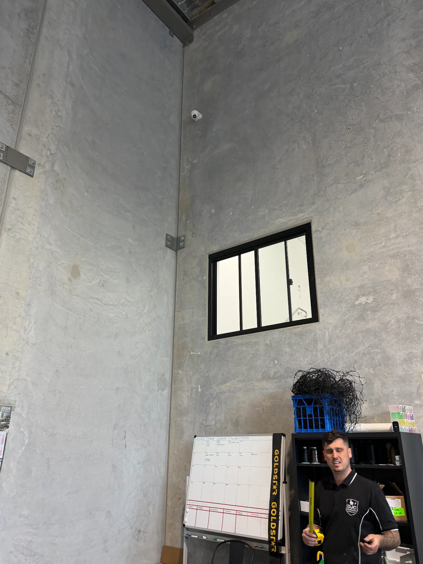 CCTV camera installed high inside a warehouse with a neat cable run