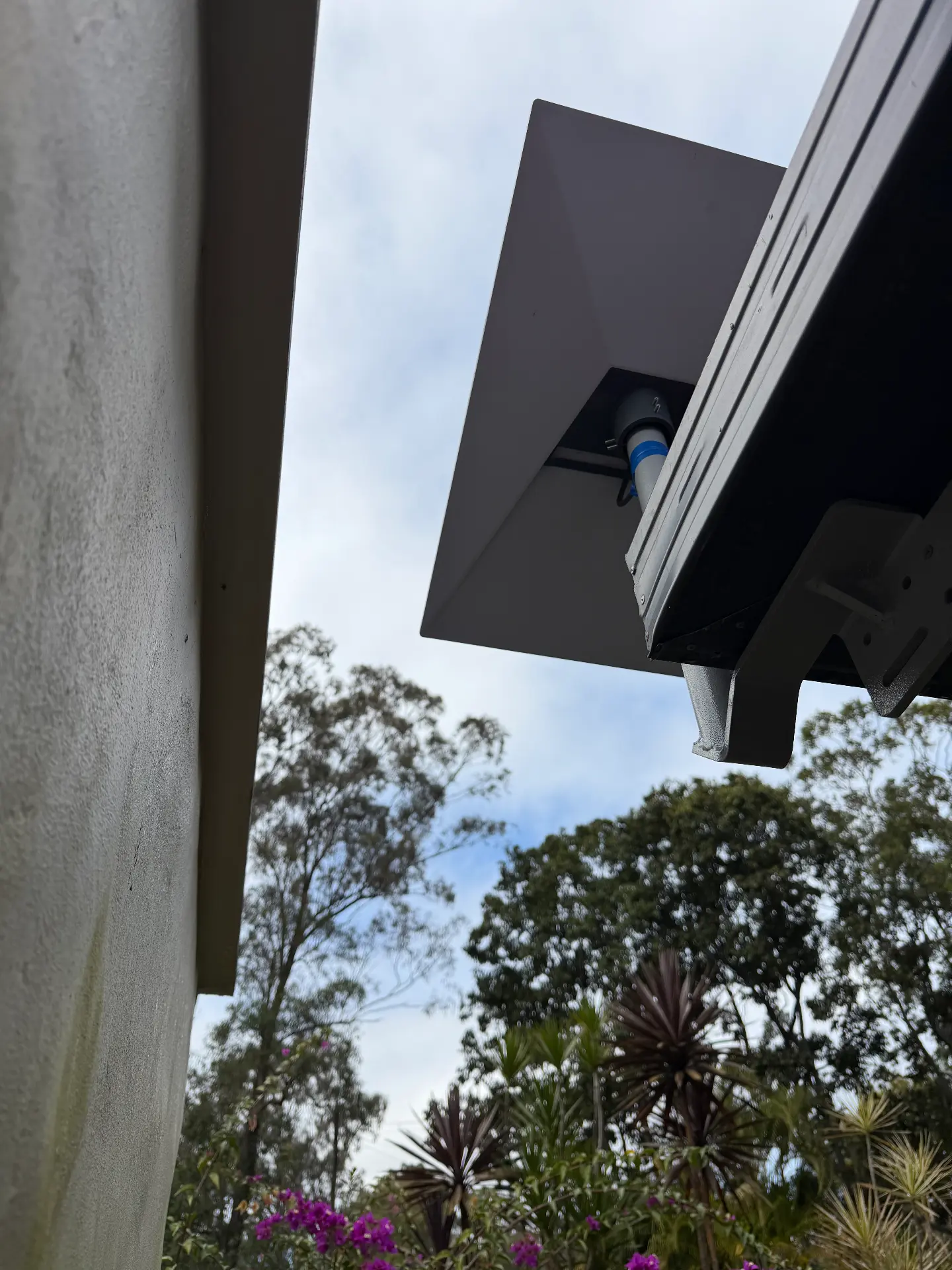 Starlink dish mounted under a roof eave with cable in conduit