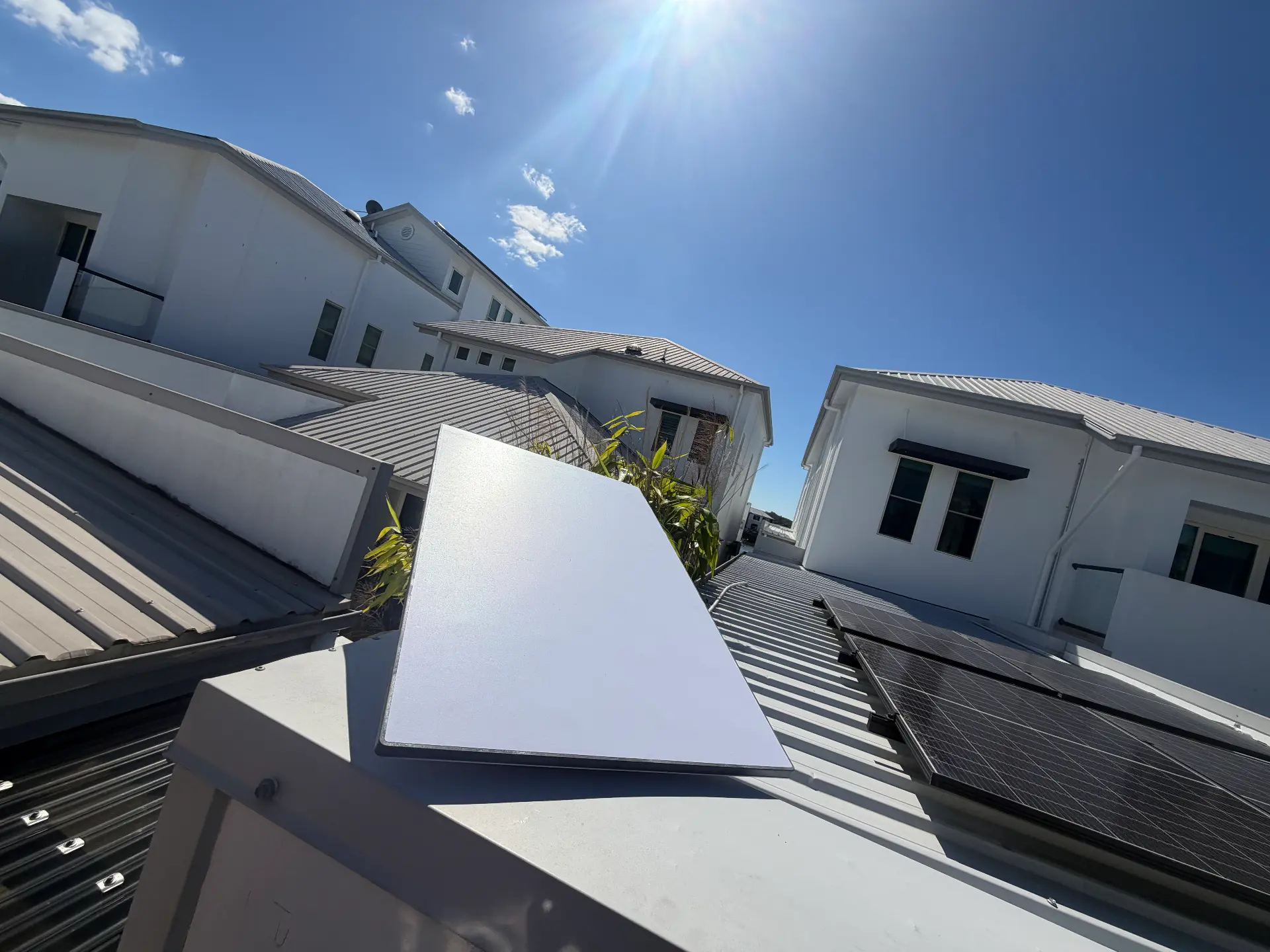 Starlink dish mounted beside solar panels on a two-storey home