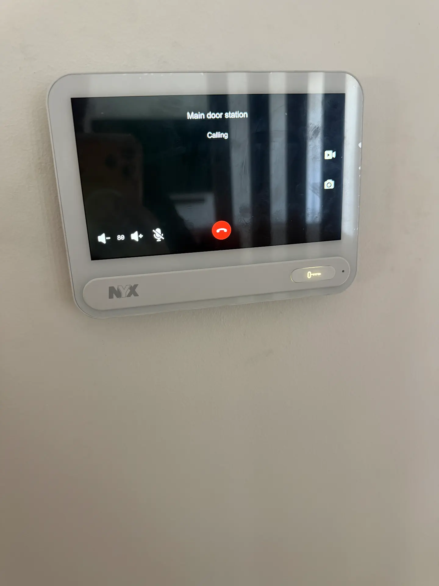 Wall-mounted video intercom screen showing a front door call