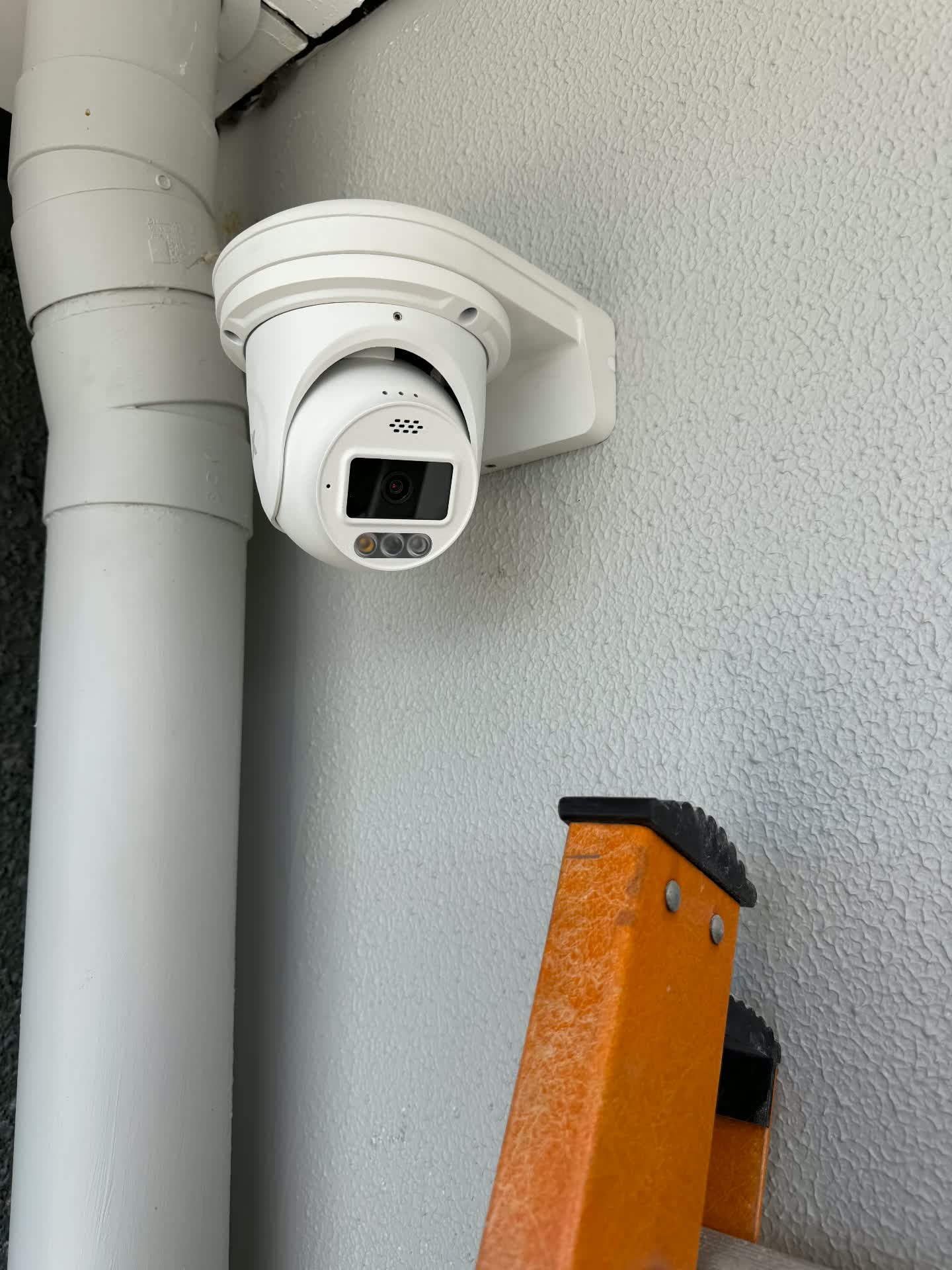 Close-up of a turret CCTV camera with spotlight and siren