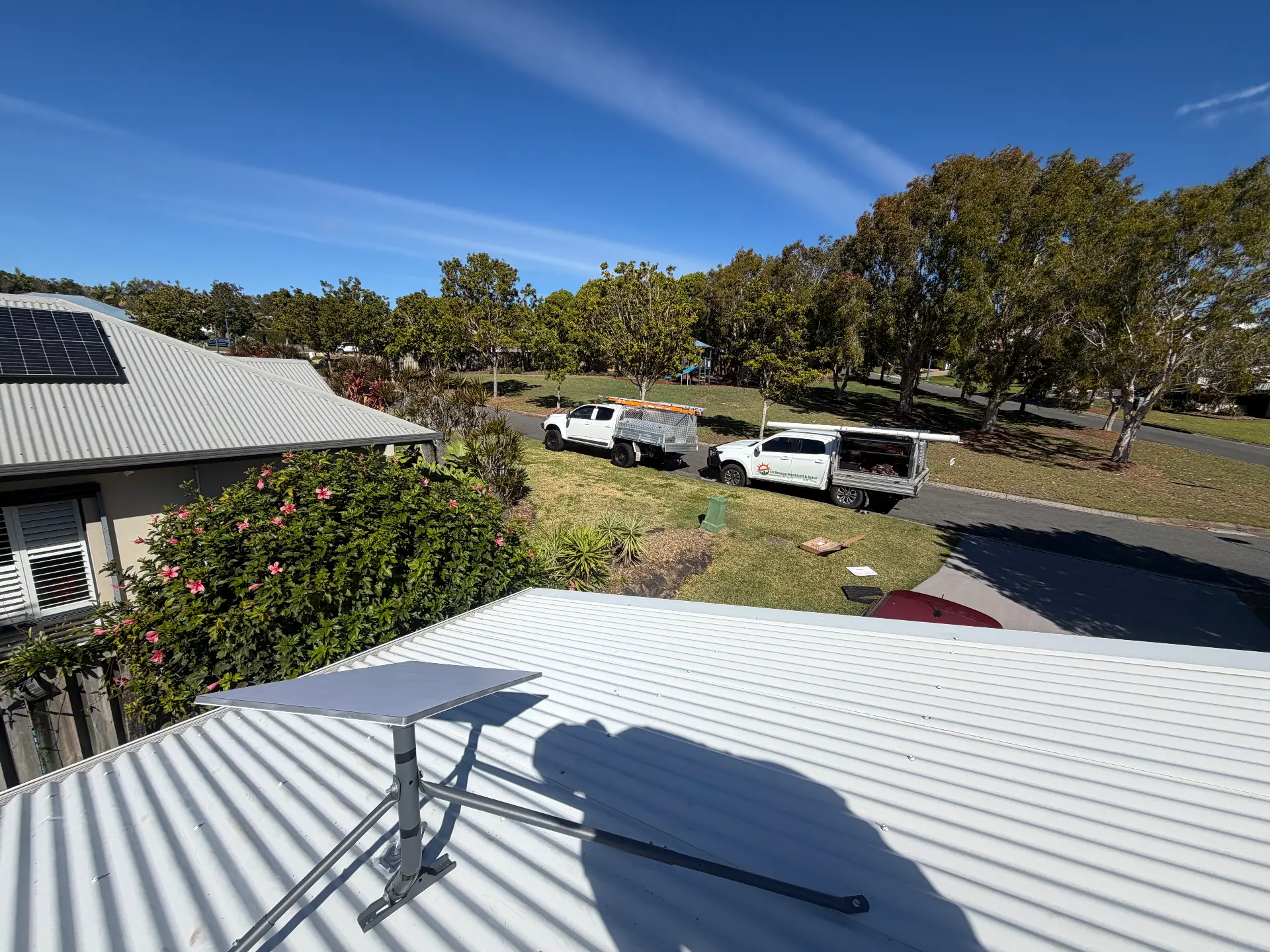 Starlink dish installed on a Gold Coast home with DJC work vehicles below